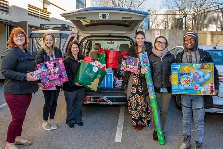 Staff members from Enrollment Services deliver gifts to Children's House