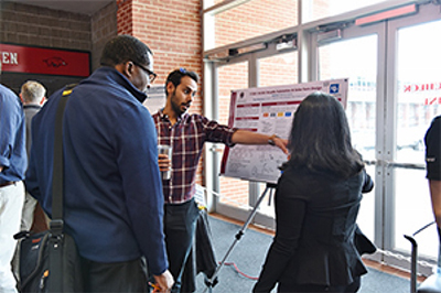 A photo of the people looking at the poster that won second-place departmental award.