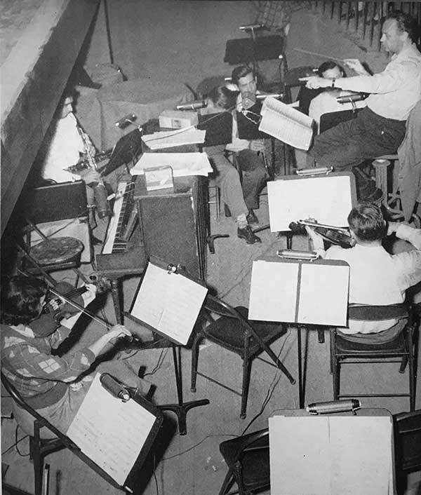 A view down into the theatre's orchestra pit with musicians rehearsing