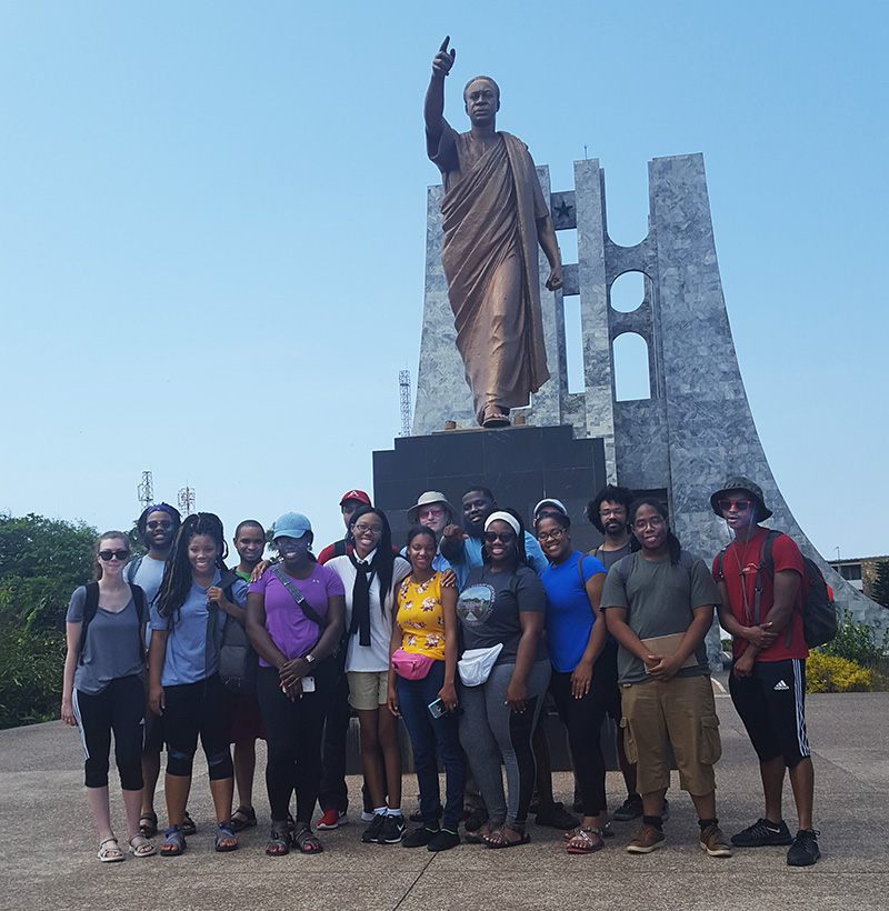 students in front of a bronze statue of Ghanas first president
