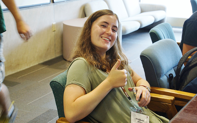 Photo of student Elizabeth Brice giving a thumbs-up to electrical engineering.