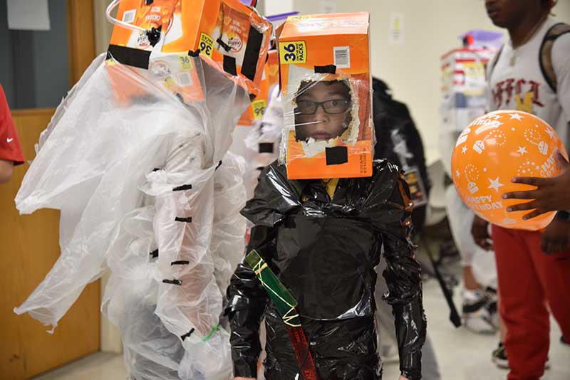 students use plastic and cardboard boxes to fashion space suits