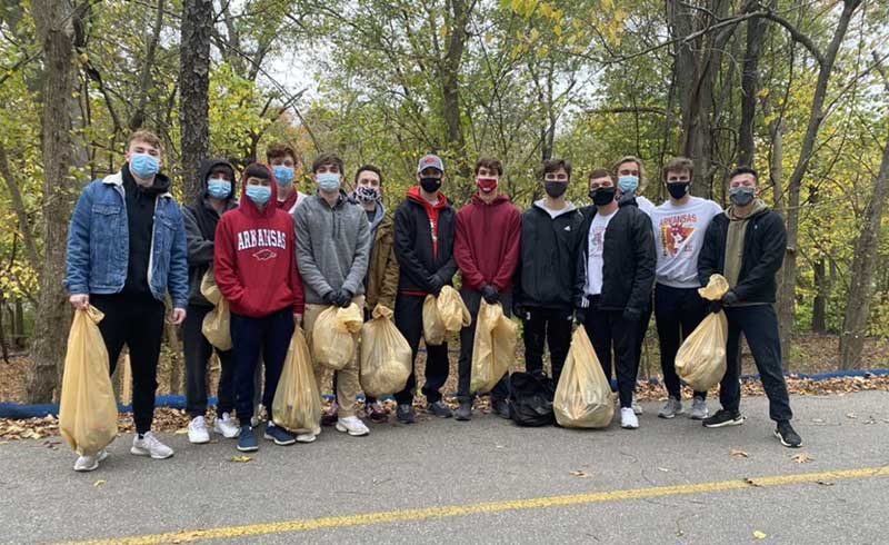 Students collect trash along a bicycle path.