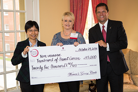 Jingyi Chen, an assistant professor of chemistry and biochemistry in Fulbright College, accepts a check for $25,000 from Women’s Giving Circle president Martha Haguewood and Associate Vice Chancellor for Development Mark Power.