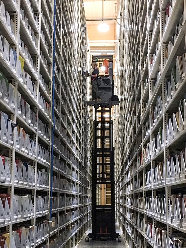A worker retrieves a book from the Library Storage Facility