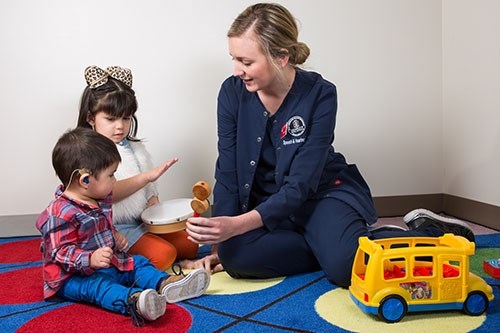 A graduate student works with children with hearing loss at the U of A Speech and Hearing Clinic.