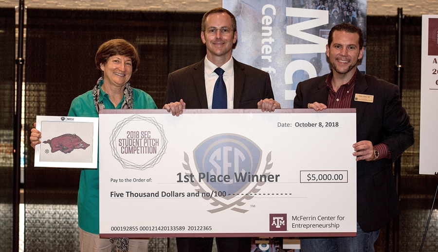 Jared Greer, center, receives the winner's check at the 2018 SEC Student Pitch Championship, with Carol Reeves, left, of the University of Arkansas and Blake Petty, right, of Texas A&amp;M University.