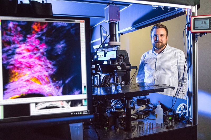 Kyle Quinn, assistant professor of biomedical engineering, with some of the imaging equipment used in his research.