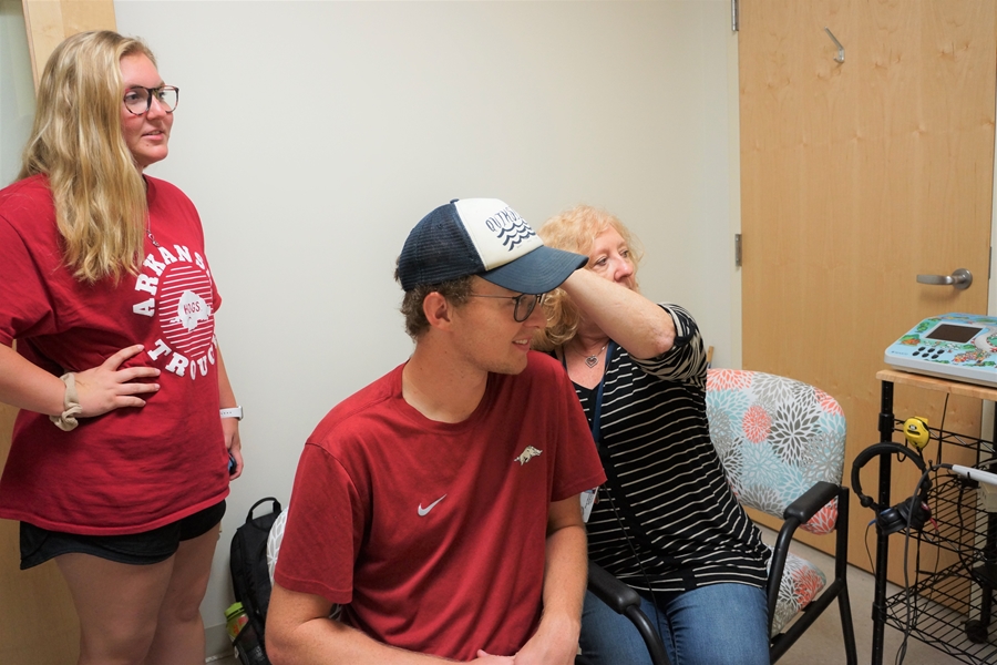 Alister Brown, who plays baritone in the Razorback Marching Band, gets fitted with custom ear plugs