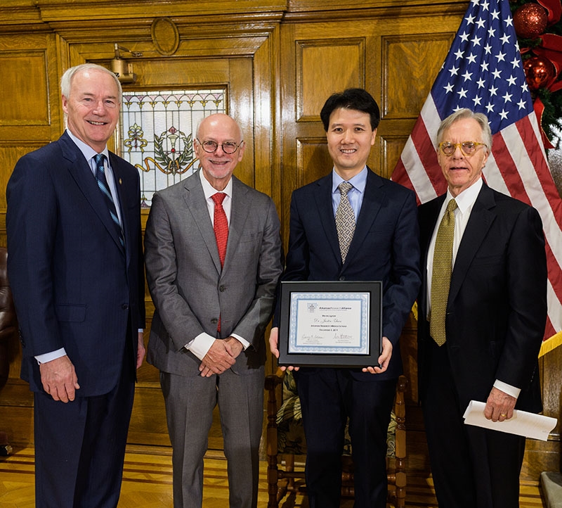 From left, Gov. Asa Hutchinson, Chancellor Joe Steinmetz, professor Justin Zhan and Jerry Adams, president and CEO of the Arkansas Research Alliance, at the Capitol Building in Little Rock.
