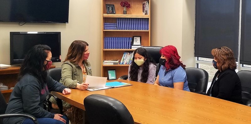 Aida Kuettle, far right, recently earned the Arkansas Bilingual Interpreter Credential in Education. Here, she's interpreting for a parent during a school meeting.
