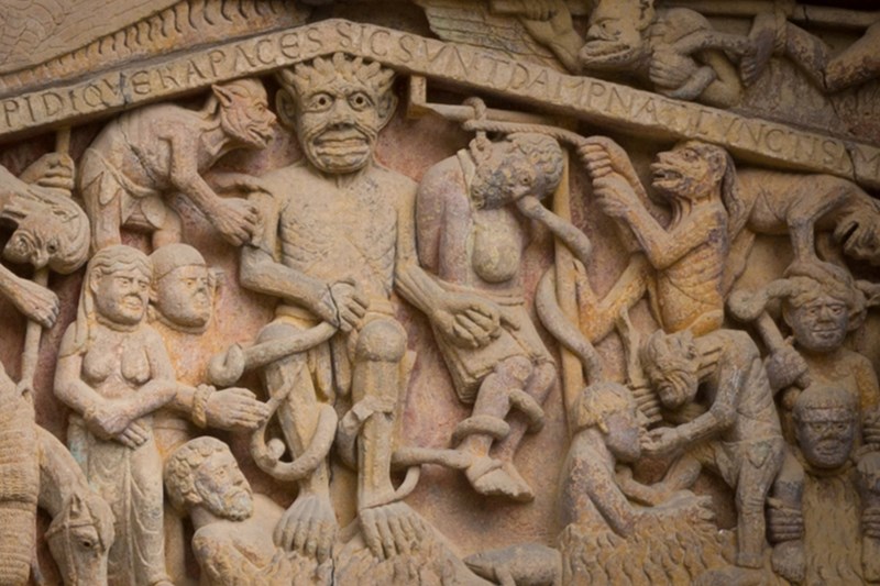 In this detail from the tympanum of the Abbey Church of Sainte-Foy in Conques, France, a usurer is shown to the devil's left, hung by his money bag. 