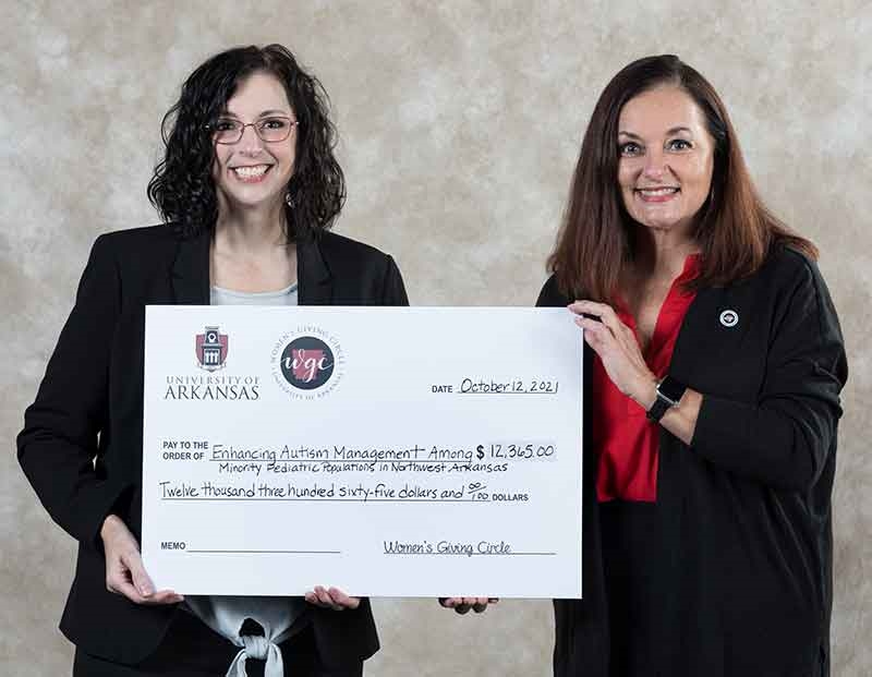 Michele Kilmer, assistant professor in the Eleanor Mann School of Nursing, receives a check from Women's Giving Circle President, Kelly Chaney.