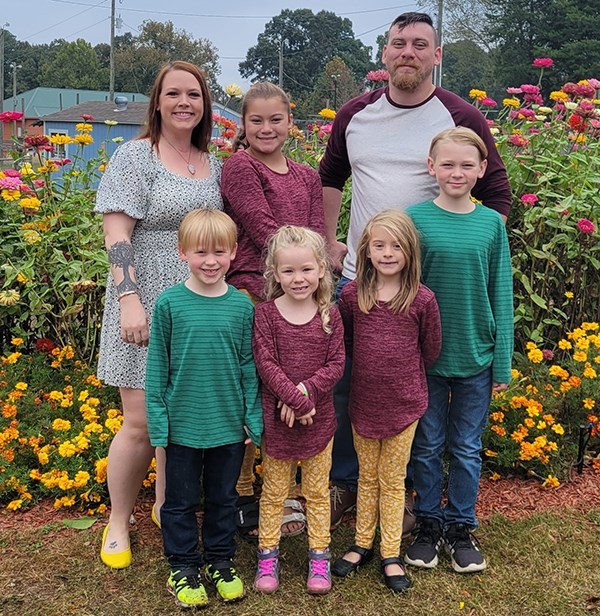 Cassie Doggett, back row, far left, is pictured with her husband, Drew Persinger, and their children, front row, from left, Bodhi, Harlyn, Arya and Wyatt and, back row, Olivia.