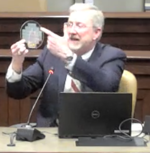 Mantooth points to silicon carbide wafer during presentation to Arkansas Legislative Council
