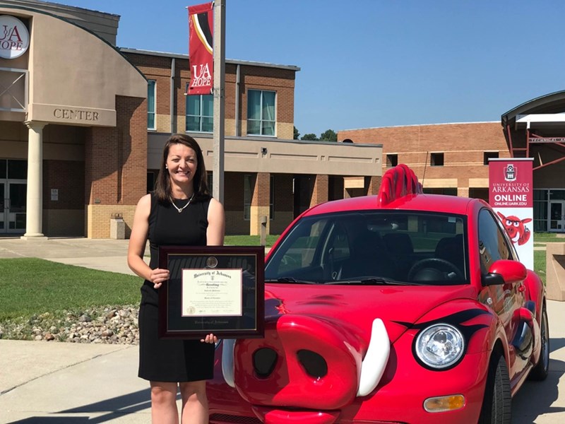 Gabrielle Patterson with her U of A diploma in front of the RazorBug on the University of Arkansas Community College at Hope-Texarkana campus in Hope.