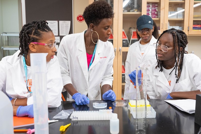 Tameka Bailey (center) talking with students in the lab.