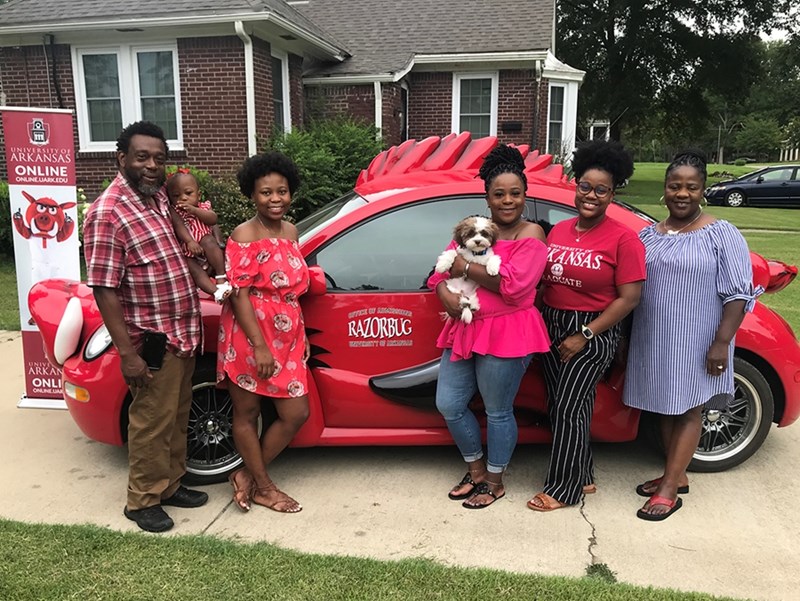 Anginay Jones, third from right, and her family pose for a photograph Aug. 3 in front of their home in Earle after Jones was presented with a framed diploma for her online Master of Science in Operations Management on the U of A RazorBug Diploma Tour through eastern Arkansas. The diploma tour celebrated graduates who earned U of A degrees online without leaving their hometowns, jobs and families.