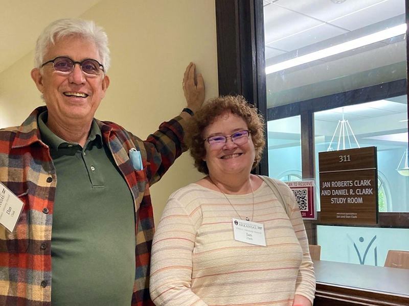 Jan and Dan Clark pose in front of the library study room named in their honor in April 2022.