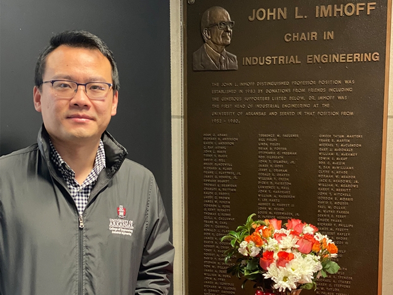 Xiao Liu and plaque honoring the late professor John L. Imhoff
