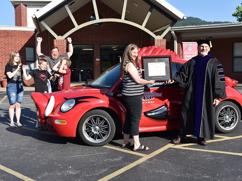 Tabitha Kolb receives her framed diploma for a Master of Education in educational technology from Ed Bengtson, associate dean of the Graduate School and International Education at the University of Arkansas, during a stop June 27 on the Razorbug Diploma Tour in front of Jasper High School.