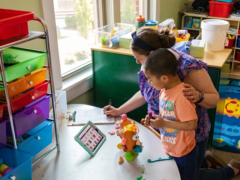 Liz Loller works with children using augmentative and alternative communication devices.